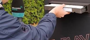 Moderator Timo Müller nimmt die Pizza aus dem Pizza-Automaten.