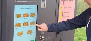 Moderator Timo Müller bestellt eine Pizza am Pizza-Automaten.