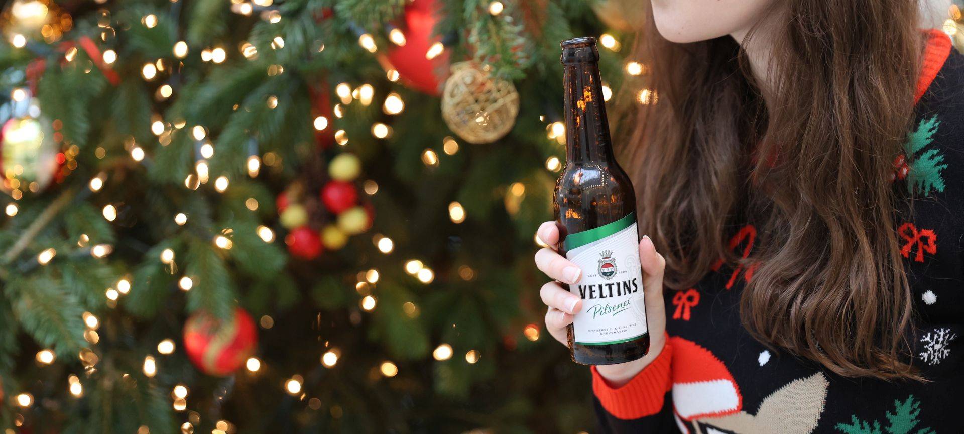 Eine Frau pustet über eine Bierflasche.