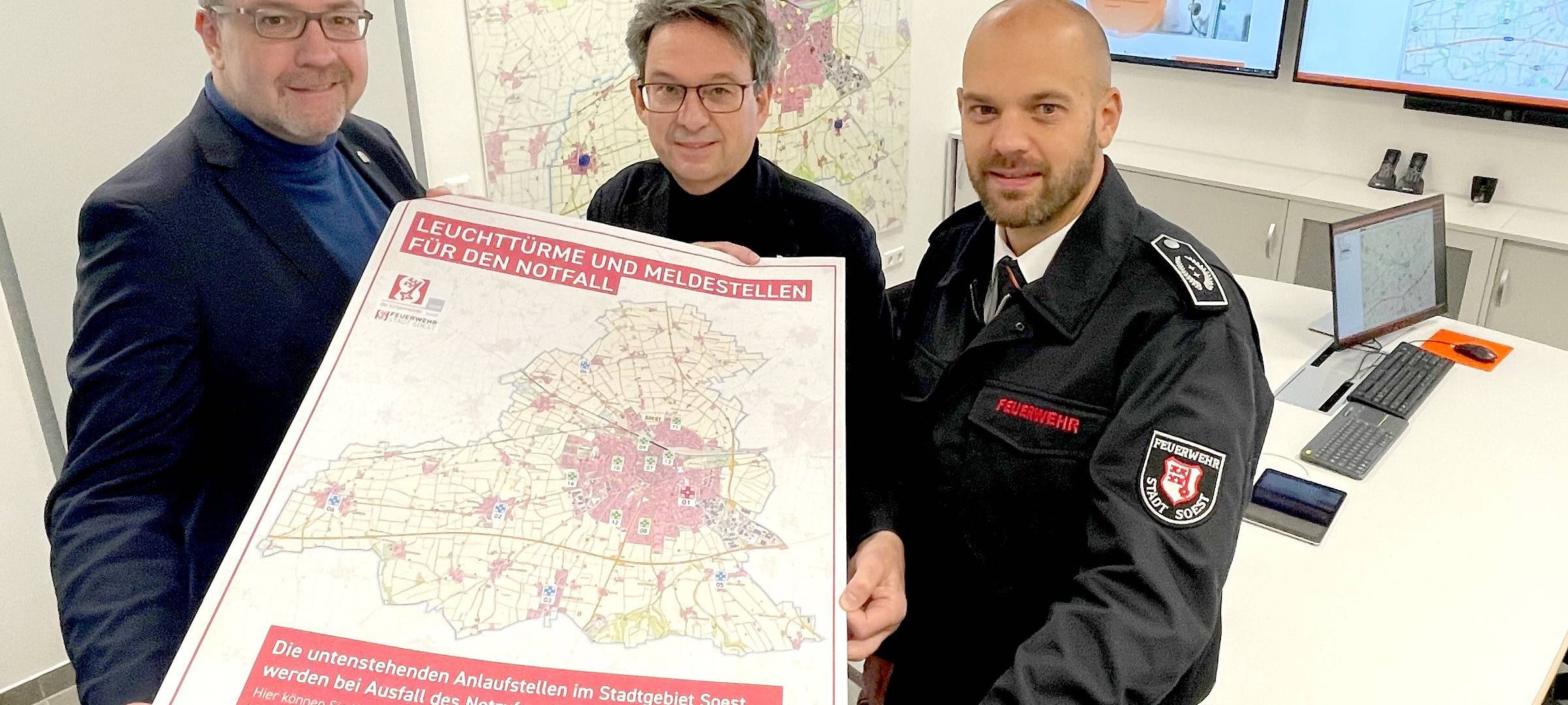 Peter Wapelhorst, Bürgermeister Dr. Eckhard Ruthemeyer, Christoph Blume mit der Karte, auf der die Anlaufstellen für die Bevölkerung im Notfall verzeichnet sind.