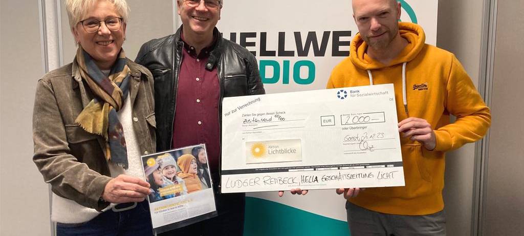 Ludger Rembeck übergibt gemeinsam mit seine Frau einen Scheck über 2.000 Euro an Hellweg Radio-Moderator André Joosten.