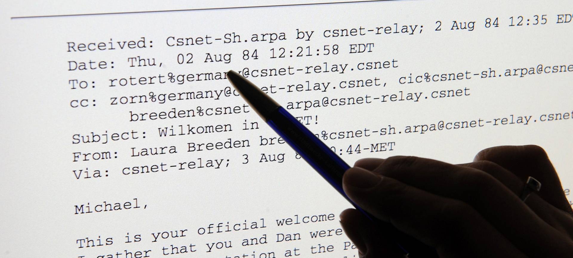 ARCHIV - ILLUSTRATION - Eine Hand zeigt am 21.07.2009 in Karlsruhe auf einem Computerbildschirm auf die erste E-Mail in Deutschland, die vor einem Vierteljahrhundert in Karlsruhe empfangen wurde. Diese empfing damals der Informatiker Werner Zorn mit seinem Team in den Räumen der Universität Karlsruhe. Die Mail kam aus den USA von Laura Breeden von der Universität Wisconsin aus dem CSNET. "Michael, this is your official welcome to CSNET", lauten die ersten Wörter an Zorn und seine Mitarbeiter. Eine Premiere: Die erste elektronische Nachricht an einen eigenen deutschen Mailserver erreicht am 2. August 1984 das Land, eine neue Ära beginnt. Foto: Uli Deck dpa/lsw (zu dpa-Korr: "Die neue Internet-Ära begann mit einem "Pling" vom 31.07.2009)