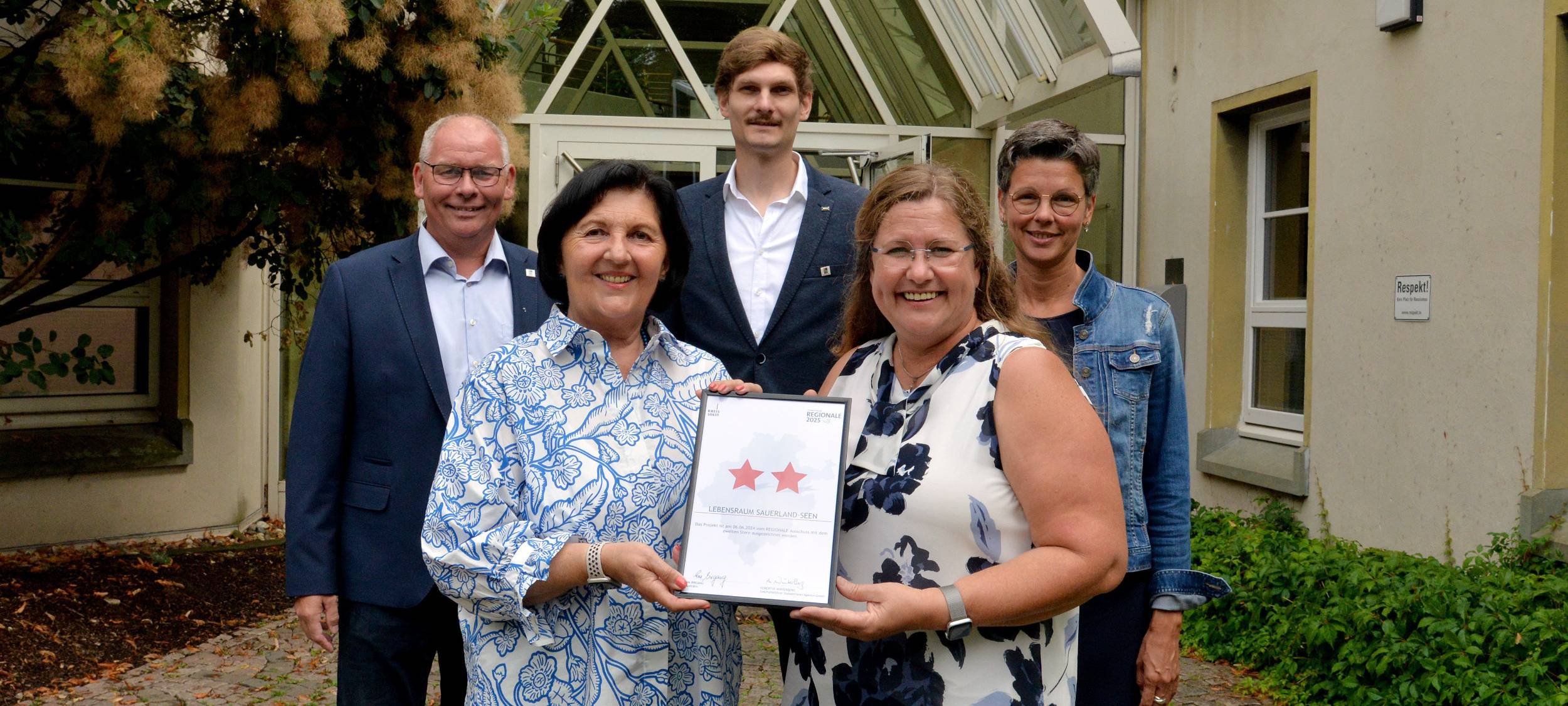 Landrätin Eva Irrgang überreicht Maria Moritz, Bürgermeisterin der Gemeinde Möhnesee, eine Urkunde.