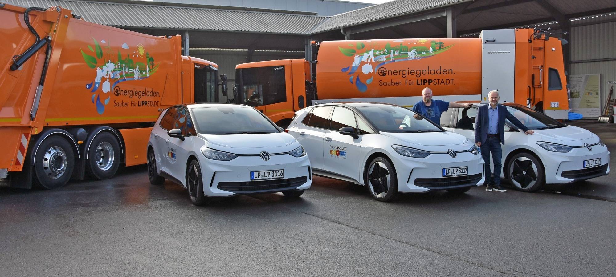 Drei E-Autos und zwei große elektrisch betriebene Müllwagen.