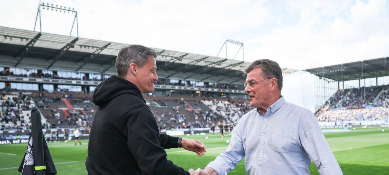 St. Paulis Trainer Alexander Blessin und Bochums Trainer Dieter Hecking (r) begrüßen sich vor dem Spiel mit einem Handschlag.