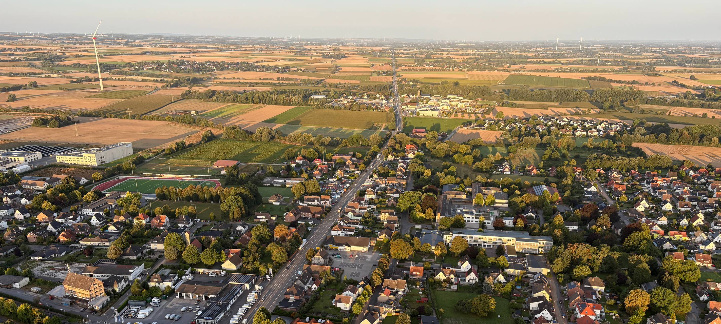 Ein Luftbild von Erwitte. Unter anderem sieht man die Hauptstraße B1 und den Sportplatz