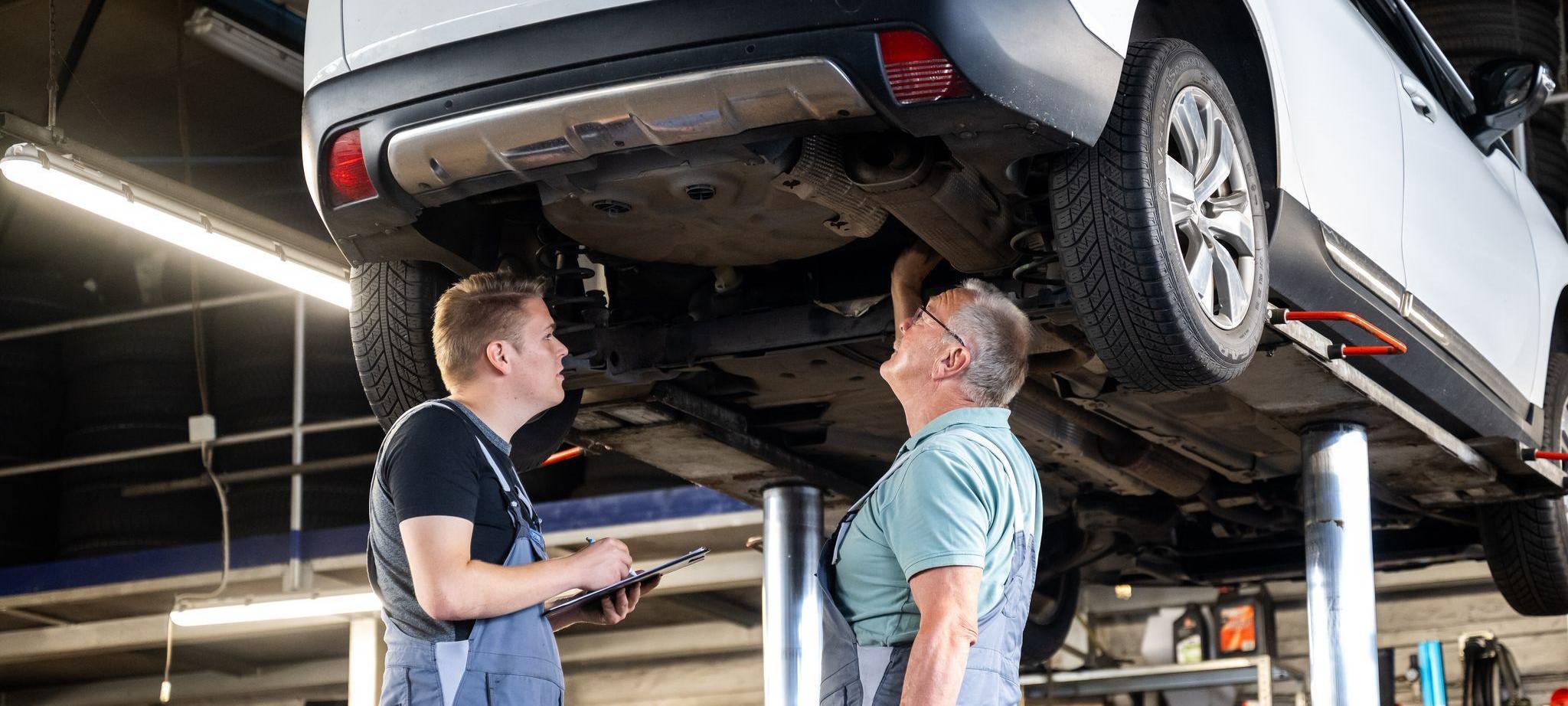 Zwei Männer arbeiten gemeinsam in einer Autowerkstatt