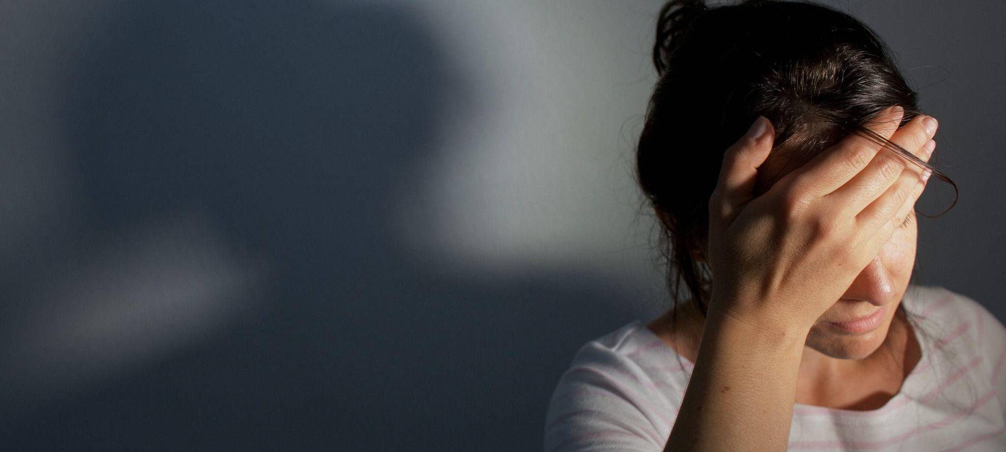 Frau fässt sich an den Kopf