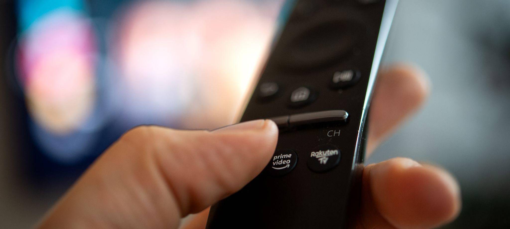 Ein Mann hält eine Fernbedienung mit der Aufschrift Amazon Prime