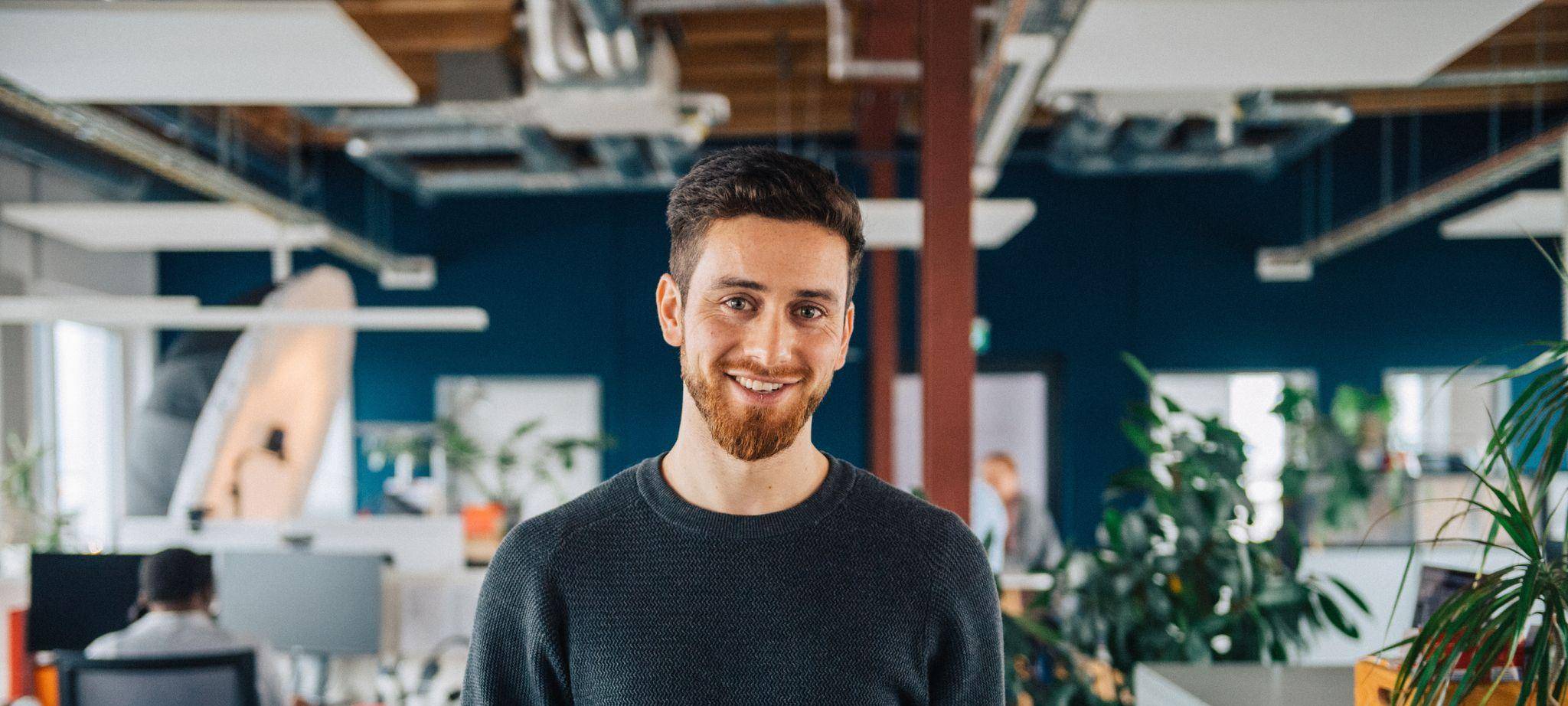 Ein Mann mit Tablet in einem Großraumbüro