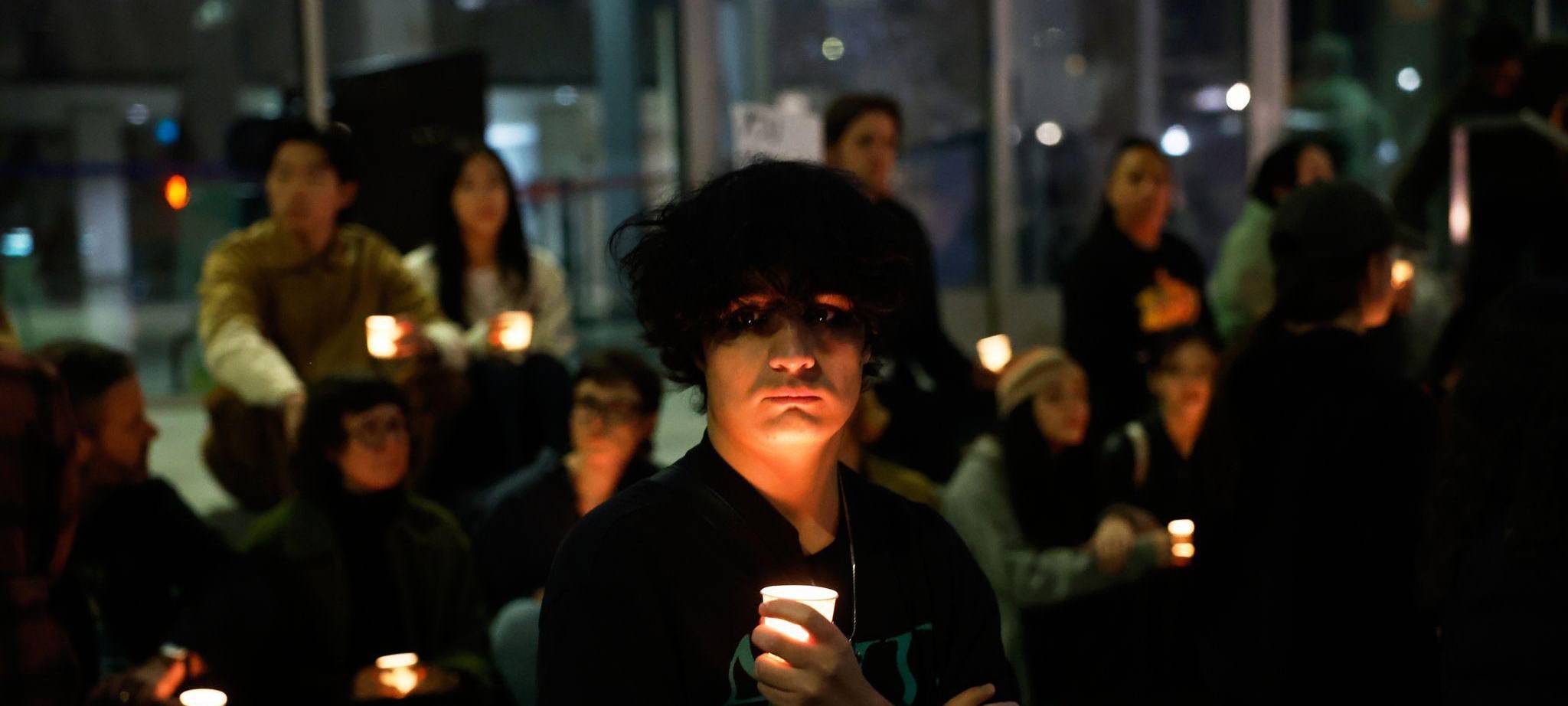Demonstranten nehmen an einer Mahnwache bei Kerzenlicht teil.