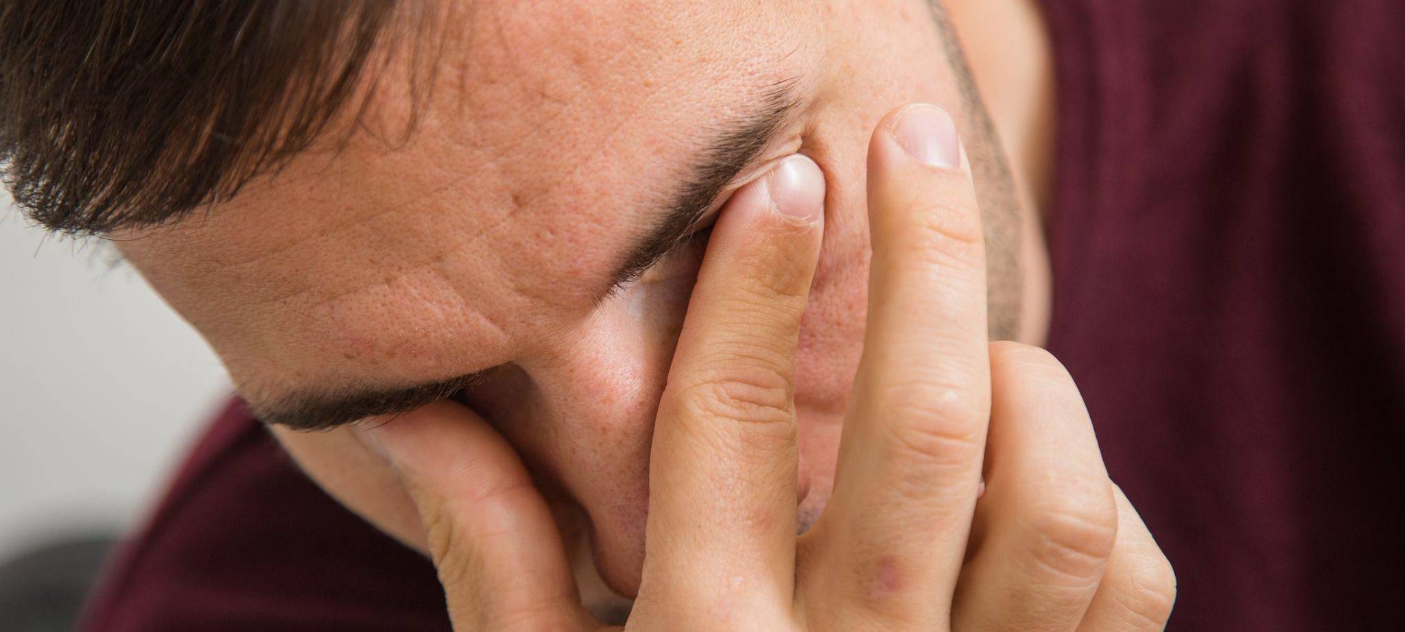 Mann fässt sich an die Augen