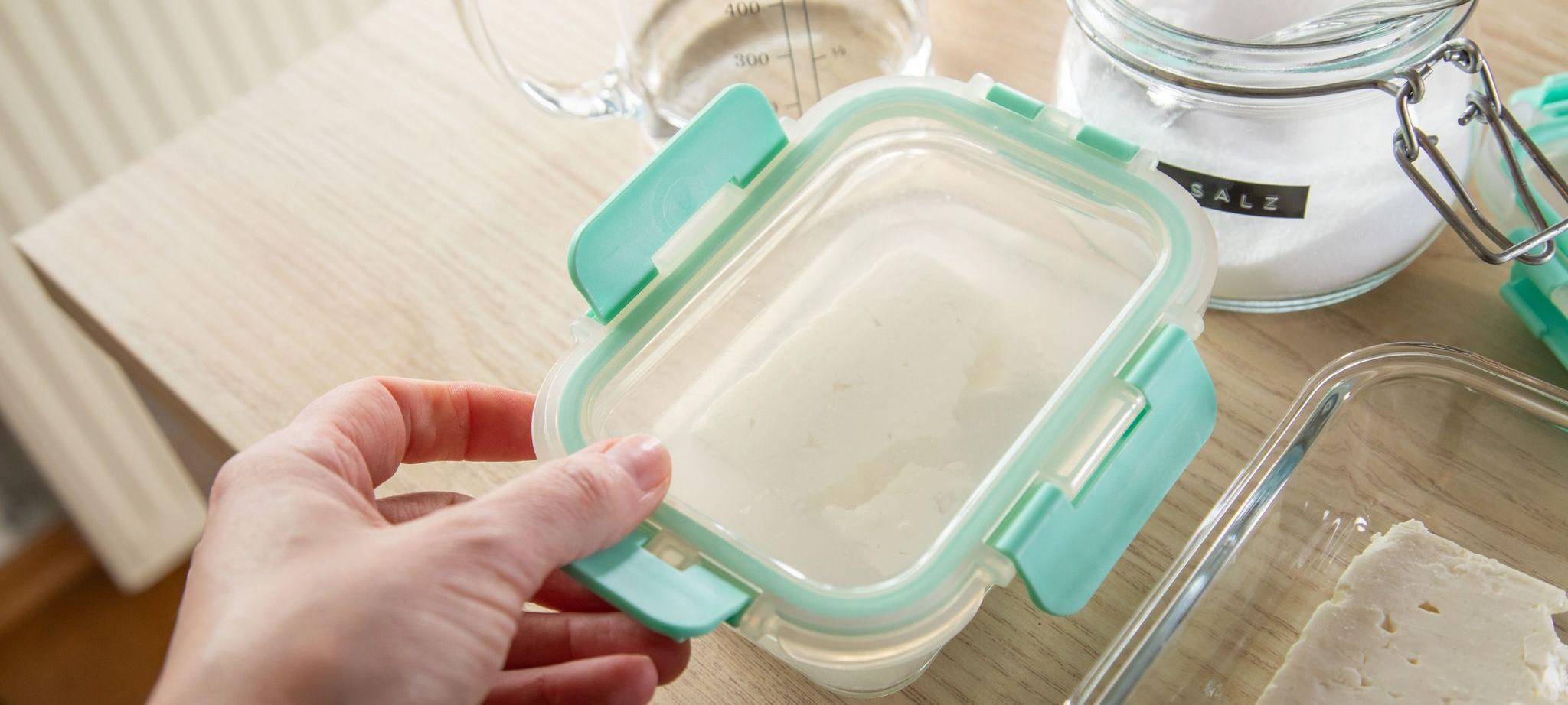 Die Schale mit Feta wird luftdicht verschlossen