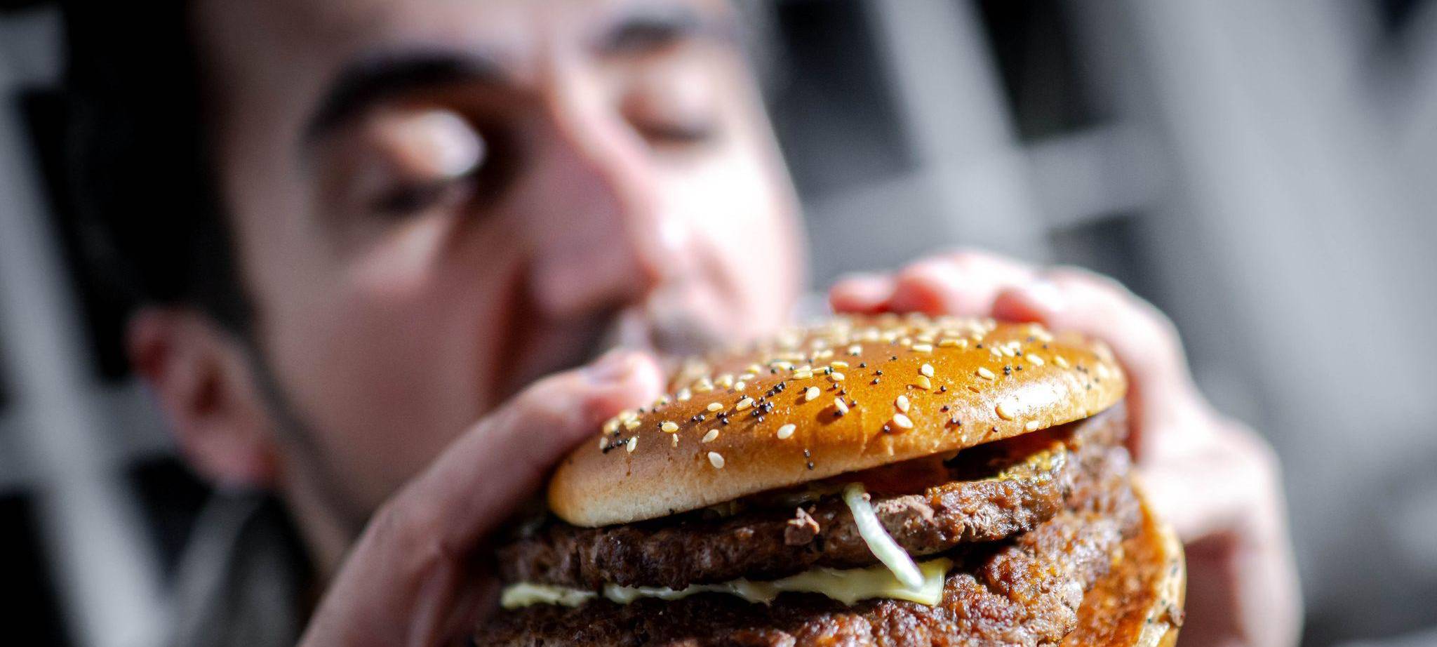 Mann beißt in einen Burger
