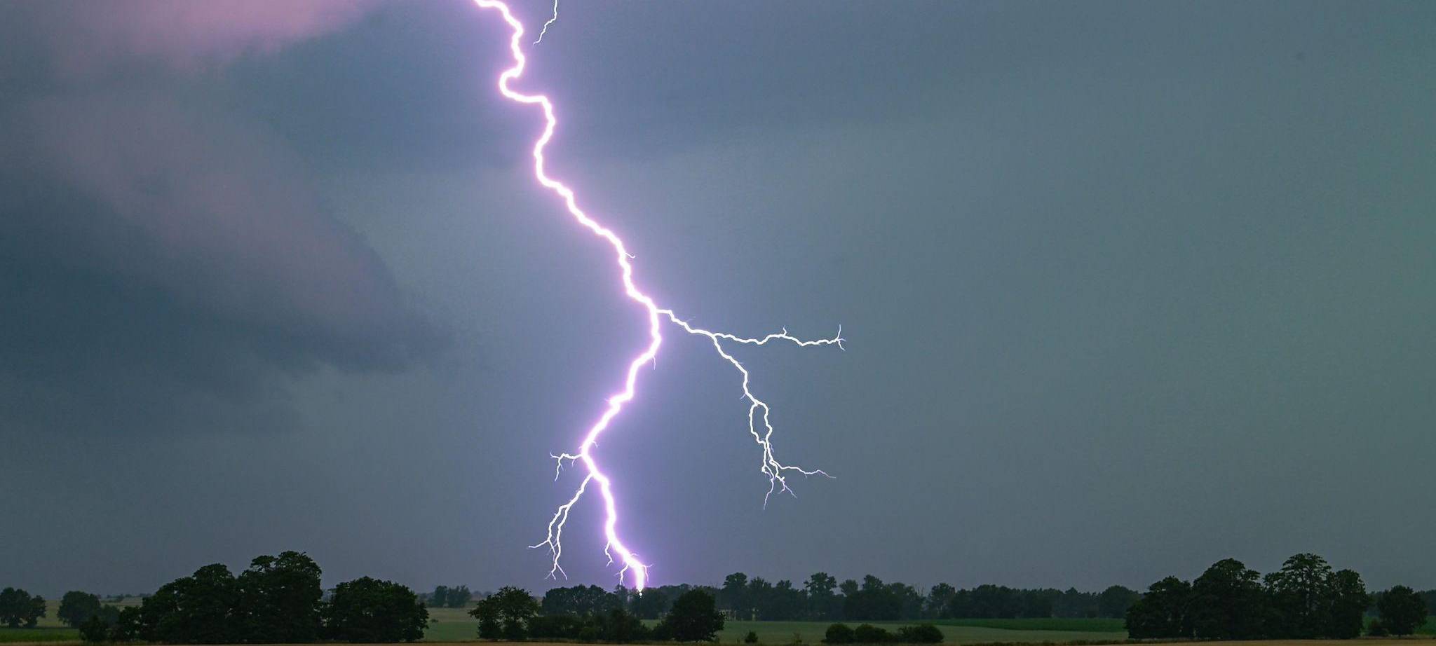 Ein Blitz leuchtet über einer Landschaft auf