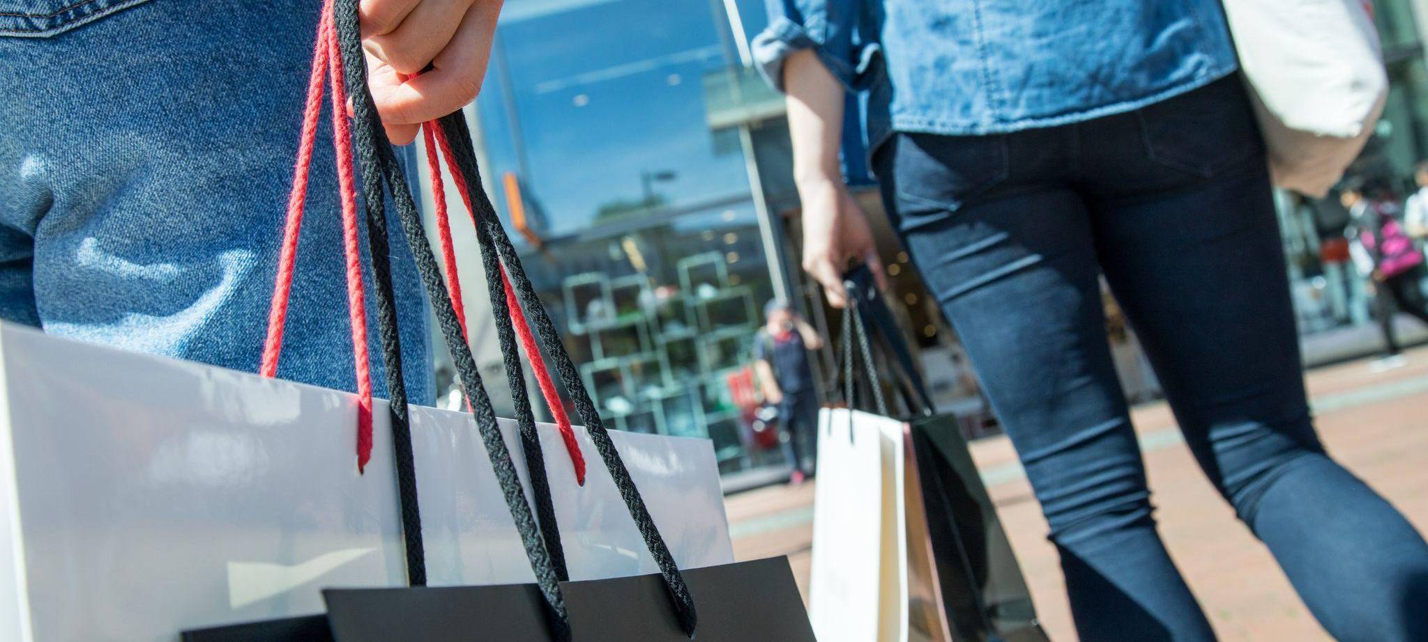 Zwei Frauen sind mit Shoppingtüten unterwegs