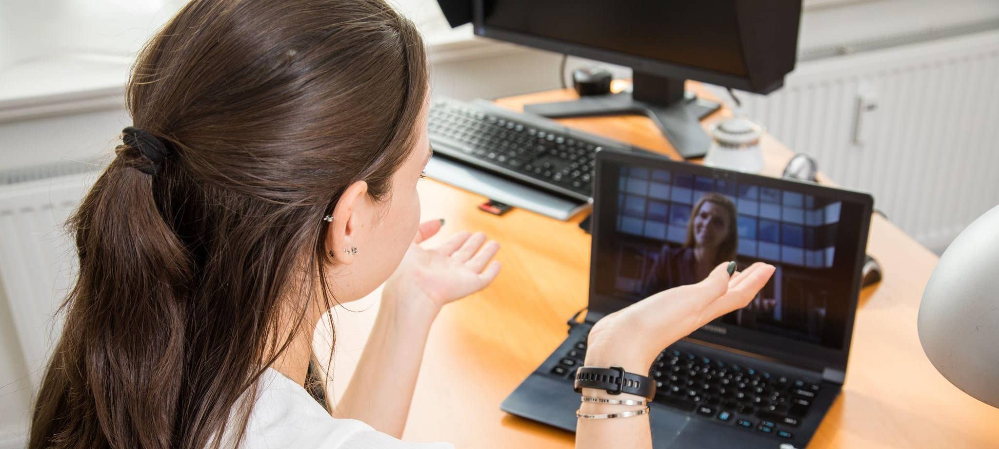 Eine junge Frau im Videocall am Laptop
