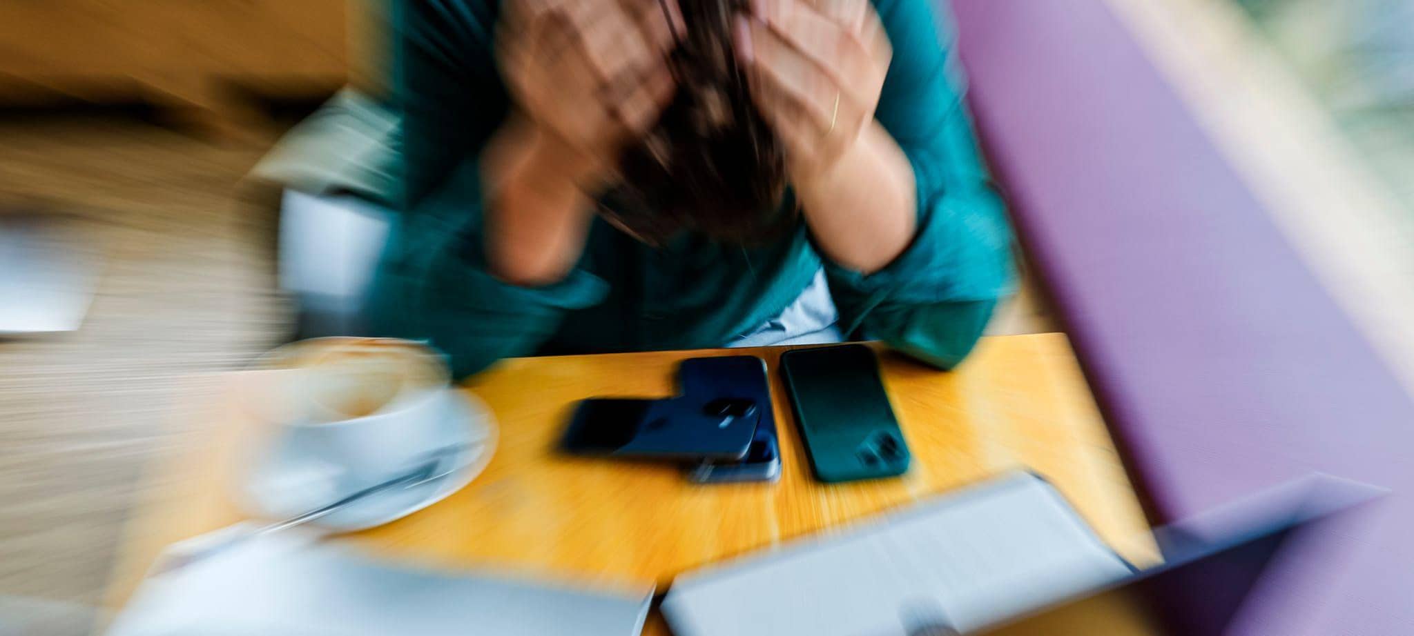 Ein Mann stützt am Arbeitsplatz seinen Kopf mit den Händen