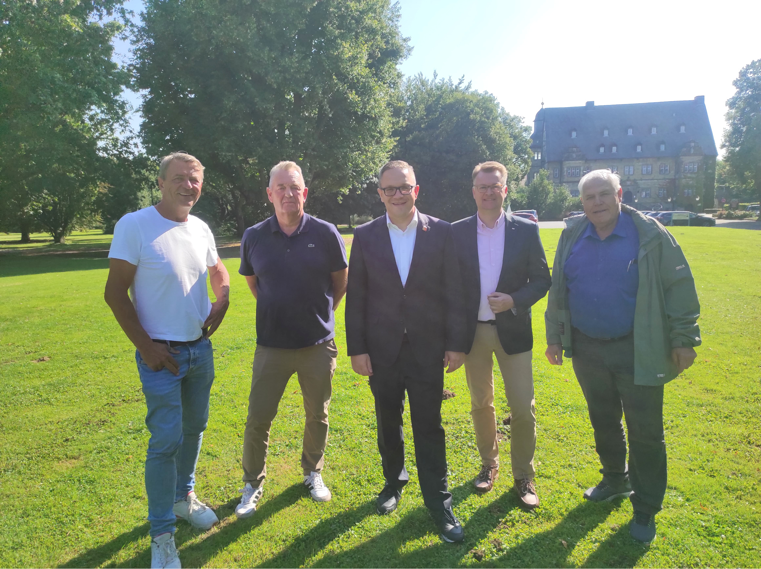 Der Bürgermeister der Stadt Erwitte steht gemeinsam mit seinen Unterstützern in einem Park.