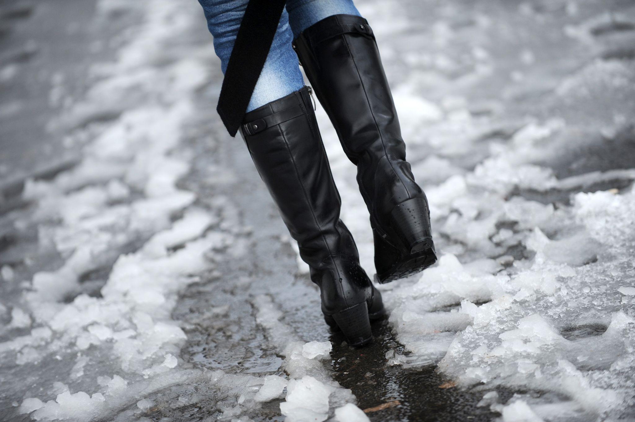 Frau läuft durch nassen Schneematsch